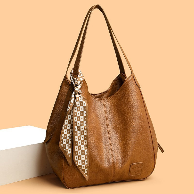Bolso tote vintage de piel suave con múltiples compartimentos.
