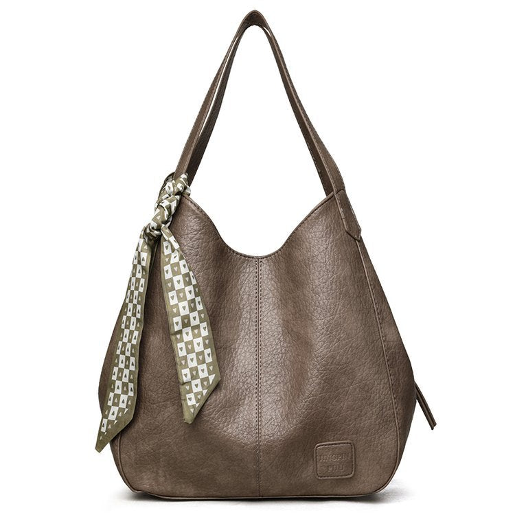 Bolso tote vintage de piel suave con múltiples compartimentos.