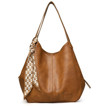 Bolso tote vintage de piel suave con múltiples compartimentos.