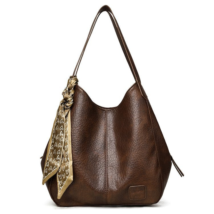 Bolso tote vintage de piel suave con múltiples compartimentos.