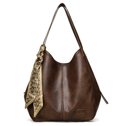 Bolso tote vintage de piel suave con múltiples compartimentos.