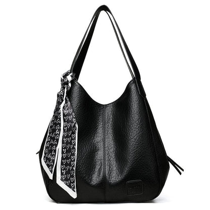 Bolso tote vintage de piel suave con múltiples compartimentos.